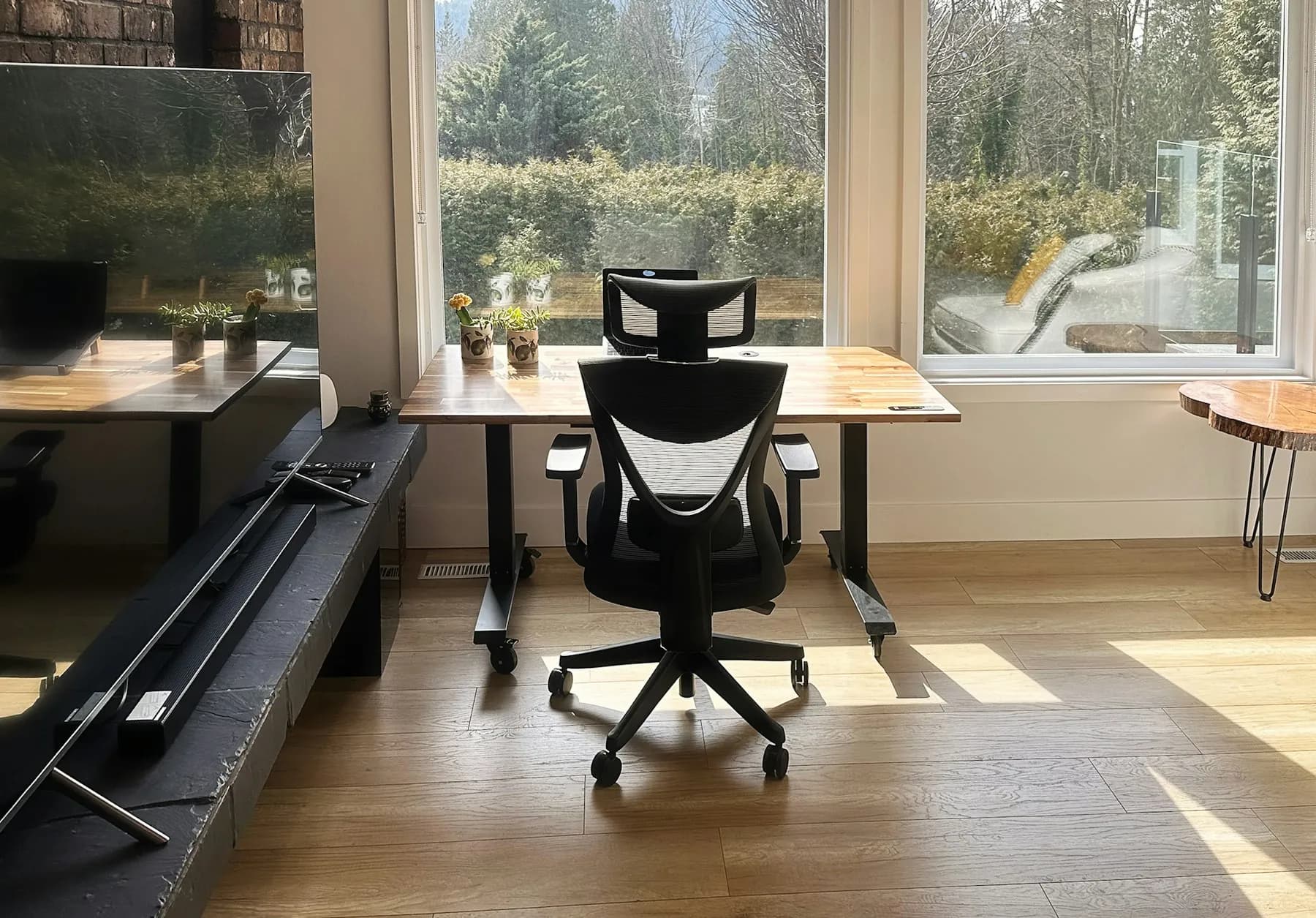 Un poste de travail vide, chaise de bureau devant une baie vitrée